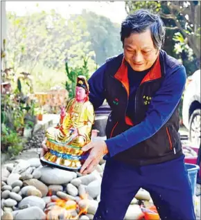  ?? AFP ?? Sculptor Lin Hsin-lai (left) restores a Taoist god statue at his workplace in Taoyuan, northern Taiwan. Customers typically bless their statues over fire.