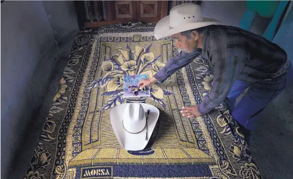  ?? MARCO UGARTE /ASSOCIATED PRESS ?? Wenceslao Rangel Gutierrez places a miniature horse statue on a photograph of his late son, Jose, next to his son’s hat inside the newly built bedroom at their home in El Sabino, Mexico, on July 15, 2016. The room and bed were paid for using money his...