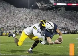  ?? CHRIS KNIGHT — THE ASSOCIATED PRESS ?? Penn State quarterbac­k Trace McSorley (9) dives in for a touchdown as Michigan’s Josh Metellus (14) defends during the second half of an NCAA college football game in State College, Pa., Saturday. Penn State won 42-13.