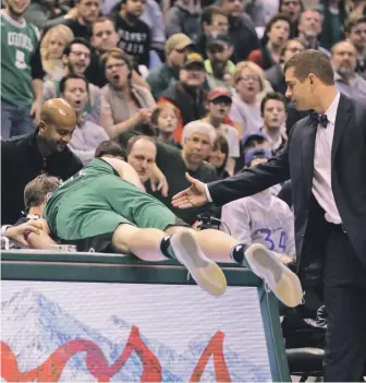  ?? STAFF PHOTO BY STUART CAHILL ?? EXTRA EFFORT: Kelly Olynyk gets a hand from Brad Stevens after trying to save a loose ball during the Celtics’ win against the Bucks last night in Milwaukee.