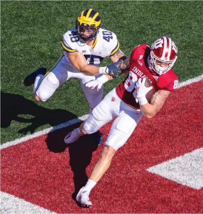  ?? DOUG MCSCHOOLER/ AP ?? Indiana’s Peyton Hendershot scores a touchdown against Michigan in the first half Saturday.