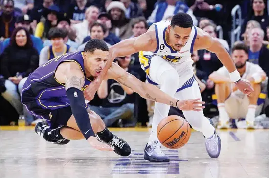  ?? ?? Los Angeles Lakers forward Juan Toscano-Anderson (left), and Golden State Warriors guard Jordan Poole scramble for the ball during the second half of an NBA basketball game in San Francisco. (AP)