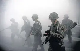  ?? KIM HONG- JI/ REUTERS FILE PHOTO ?? South Korean soldiers walk through smoke as they take part in an anti- terror and security drill at the Integrated Government Complex in Sejong, south of Seoul.