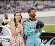  ?? Phelan M. Ebenhack / Associated Press ?? Bubba Wallace, right, stands next to his vehicle with his fiancé, Amanda Carter, on pit road before a NASCAR Cup Series auto race at Daytona Internatio­nal Speedway in 2021.