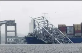  ?? MATT ROURKE — THE ASSOCIATED PRESS ?? A container ship rests against the wreckage of the Francis Scott Key Bridge on Thursday in Baltimore. The bridge fell within seconds after the ship hit it.