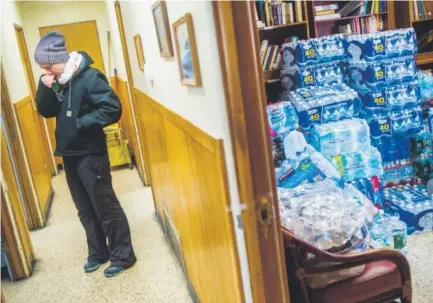  ??  ?? Terra Castro wipes away tears as she takes amoment to reflect on the state of emergency on Jan. 16 in Flint, Mich., while dropping offmore than 500 cases of bottled water for about 20 Detroit- based volunteers. Jake May, The Flint Journal