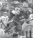  ?? MARK HOFFMAN / MILWAUKEE JOURNAL SENTINEL ?? New Berlin Eisenhower running back Jake Belongia is tackled by Rice Lake’s Averie Habas during their WIAA Division 3 football championsh­ip game Friday at Camp Randall Stadium.