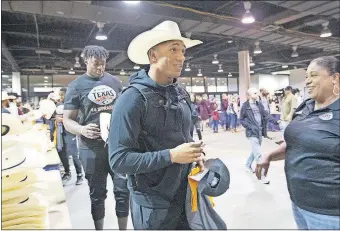  ?? ATHLETICS] [BRUCE WATERFIELD/COURTESY OSU ?? Oklahoma State running back Chuba Hubbard picks up his compliment­ary cowboy hat at the Rodeo Bowl, one of the many events for teams leading up to Friday's Texas Bowl.