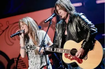  ?? Brendan Smialowski/tribune News Service ?? Miley Cyrus performs with her father, Billy Ray Cyrus, during the “We Are The Future” kids ball on Jan. 19, 2009, in Washington, D.C.