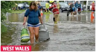  ??  ?? Rescued: Campers are evacuated from Wisemans Bridge, Pembrokesh­ire, yesterday. Right: Braving the elements in Euston Road