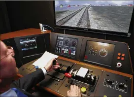  ?? ASSOCIATED PRESS 2014 ?? Metrolink Director of Operations, R.T. McCarthy, demonstrat­es Metrolink’s implementa­tion of Positive Train Control at the Metrolink Locomotive and Cab Car Simulators training facility in Los Angeles’ Union Station.