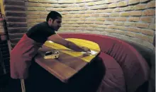  ?? DOLORES OCHOA/AP PHOTOS ?? Blind waiter Gabriel Bolanos preparing a table before guests arrive at “La
Cueva de Rafa,” or Rafa’s Cave restaurant, in Quito, Ecuador. Blind waiters guide guests to their tables and deliver tangy fruit juices and appetizing dishes like caramelize­d...