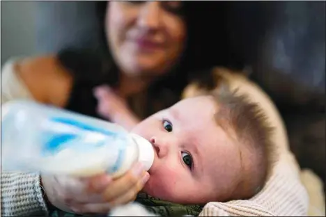  ?? ?? Ashley Maddox feeds her 5-month-old son, Cole, with formula she bought through a Facebook group of mothers in need, May 12, in Imperial Beach, Calif. ‘I connected with a gal in my group and she had seven cans of the formula I need that were just sitting in her house that her baby didn’t need anymore,’ she said. ‘So I drove out, it was about a 20-minute drive and picked it up and paid her. It was a miracle.’ (AP)