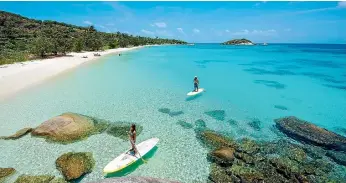  ??  ?? Stand-up paddleboar­ding is just one of many ways to pass the time on Lizard Island.