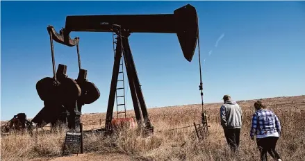  ?? Helen H. Richardson/Tribune News Service ?? Landowners Ron and Cindy McCormick walk near a pumpjack and other abandoned oil and gas equipment on their property in Hudson, Colo. The couple has joined a lawsuit accusing two companies of “massive fraud” for their handling of the well’s cleanup.