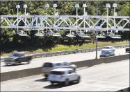  ?? Associated Press file photo ?? Cars pass under toll-sensor gantries hanging over the Massachuse­tts Turnpike in Newton in 2016.