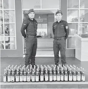 ??  ?? SELUDUP: Pegawai polis marin menunjukka­n minuman keras seludup yang dirampas.