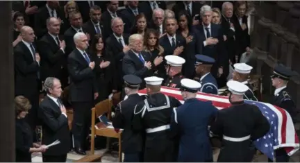  ?? ASSOCIATED PRESS PHOTOS ?? The flag-draped casket of former President George H.W. Bush is carried by a military honor guard past former President George W. Bush, President Donald Trump, first lady Melania Trump, former President Barack Obama, Michelle Obama, former President Bill Clinton, and former Secretary of State Hillary Clinton, at the conclusion of a State Funeral at the National Cathedral, Wednesday in Washington. In the second row are Vice President Mike Pence, and his wife Karen Pence, former Vice President Dan Quayle, and his wife Marilyn Quayle and former Vice President Dick Cheney, along with former Vice President Al Gore.