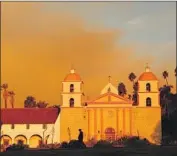  ??  ?? SMOKE RISES behind the Santa Barbara Mission on Tuesday morning as the Cave fire chars the hills.