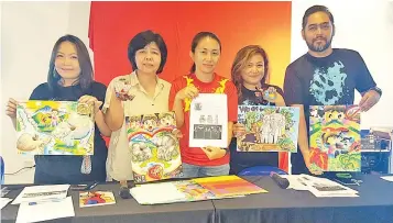  ??  ?? June (centre), Melissa (second right) and their organising crew showing the medals for previous runs held by the company and some of the drawings from the awareness drawing competitio­ns.