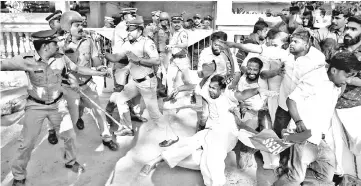  ??  ?? A police officer wields his stick against the members of Kerala Students Union (KSU), the student wing of India’s main opposition Congress party, outside a police station during a protest in Kochi, India. — Reuters photo