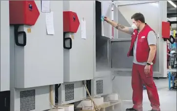  ?? Matthias Schrader Associated Press ?? AN EMPLOYEE OF Binder GmbH checks an ultra- low- temperatur­e freezer. Such freezers will be in high demand for a COVID- 19 vaccine that must be cooled at minus- 94 degrees Fahrenheit for shipping and storage.