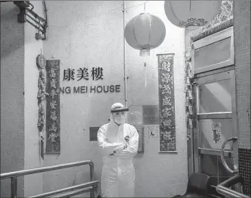  ?? Billy H.C. Kwok Getty Images ?? AN OFFICIAL guards a Hong Kong apartment building. Inovio Pharmaceut­icals, which designed a synthetic vaccine for COVID-19 at its San Diego lab, hopes to begin clinical testing this summer in the U.S. and China.