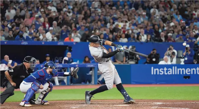  ?? NATHAN DENETTE/AP ?? Aaron Judge hits a two-run home run, his 61st of the season to tie Roger Maris’ American League record, in the seventh inning Wednesday against the Blue Jays in Toronto.