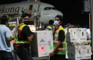  ?? (Avito C. Dalan/PNA) ?? MORE JABS. Workers carry boxes of the Pfizer vaccine at the Ninoy Aquino Internatio­nal Airport Terminal 3 in Pasay City on Thursday night (Sept. 23, 2021). The bulk of the total 728,910 doses will be allotted to the National Capital Region, other major cities in Luzon, Cebu, and Davao.