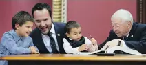  ?? JACQUES BOISSINOT/ THE CANADIAN PRESS ?? Quebec Family Minister Mathieu Lacombe tries to keep a handle on his sons during Thursday’s signing in ceremony at the National Assembly.