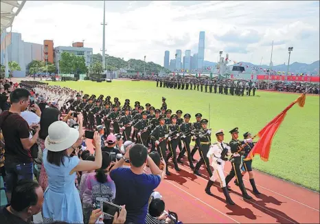  ?? CHEN JIE / FOR CHINA DAILY YANG SHUAI / FOR CHINA DAILY ?? Clockwise from left: Soldiers from the People’s Liberation Army Garrison in Hong Kong parade the national flag during an open day at their barracks. learn how to board a new type of infantry vehicle. A group of soldiers chat during a rest period.