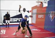  ?? AP PHOTO ?? Williams driver Nicholas Latifi (front) tries to drive around former NBA player Dikembe Mutombo in the lead-up to the Formula One U.S. Grand Prix at Circuit of the Americas Thursday in Austin, Texas.