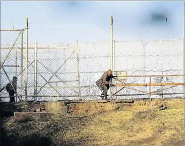  ?? PHOTO: THULANI MBELE ?? SNICKING IN: A man illegally crosses into South Africa through a hole in the fence on the Ficksburg Bridge border control linking Lesotho and South Africa. Ficksburg experience­s a high volume of Lesotho nationals crossing the border daily
