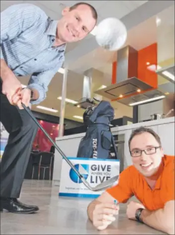  ?? Photo: GLENN FERGUSON ?? CHIPPING IN: Bill Mithen, of Give Where You Live, practises his chipping with help from E&S Trading’s Paul Ryan.