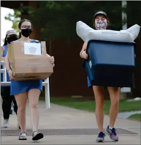  ?? (NWA Democrat-Gazette/Andy Shupe) ?? Volunteers help first-year University of Arkansas students and their families move into dormitory rooms Thursday on the campus in Fayettevil­le.