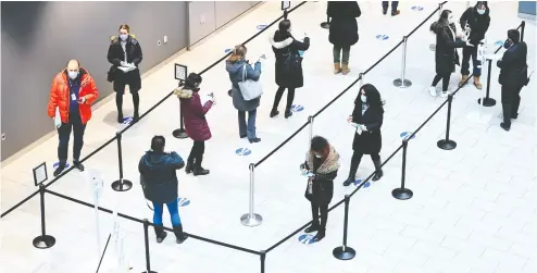  ?? Nathan Denett e / THE CANADIAN PRESS ?? Health- care workers wait in line for the jab at a COVID-19 vaccine clinic in Toronto on Thursday.