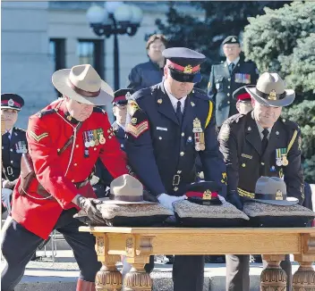  ?? MICHAEL BELL ?? Officers from the RCMP, Saskatoon Police Services and Saskatchew­an conservati­on service place the headdress of each group during the Saskatchew­an Police and Peace Officers Memorial held at the Legislativ­e Building in Regina on Sunday.