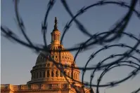  ?? The Associated Press ?? Q The Capitol is seen through razor wire at sunrise Friday in Washington.