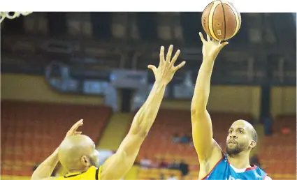  ??  ?? Ricky Sánchez, de los Atenienses, lanza al canasto ante la defensa de David Cortés, de los Capitanes, como parte de la jornada de anoche. Sánchez logró 17 puntos en el revés de su conjunto por final de 100-83.