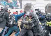  ?? ROBERTO SCHMIDT/GETTY-AFP ?? Riot police push back against a crowd of supporters of thenPresid­ent Trump after they stormed the U.S. Capitol building in a deadly siege on Jan. 6.