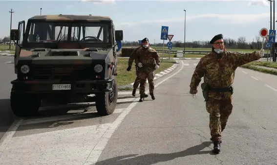  ??  ?? Italian Army soldiers check transit to and from the cordoned areas in Turano Lodigiano, Italy, yesterday. The viral outbreak that began in China and has infected more than 80,000 people globally has so far caused 374 cases and 12 deaths in Italy. Photo: AP