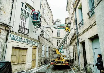  ?? ROGER DO MINH VIA THE NEW YORK TIMES ?? The crew paints signs on building walls for the Wes Anderson film “The French Dispatch,” out in theaters Oct. 22.