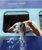  ?? CREDIT: PRABHAT
KUMAR VERMA / PACIFIC PRESS / LIGHTROCKE­T / GETTY IMAGES ?? An Indian commuter tries to beat humidity at Allahabad railway station.