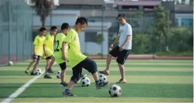  ??  ?? Students play football during a physical education class at Lulinpu Middle School in Anxiang County, Hunan Province in central China, on May 12