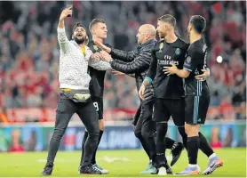  ?? Picture: GETTY ?? ONE FOR THE ALBUM: A pitch invader tried to take selfie with Real Madrid players during last month’s Uefa Champions League semifinal, first leg match between Bayern Munich and Real Madrid in Munich