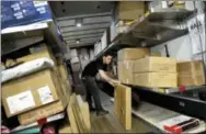  ?? THE ASSOCIATED PRESS ?? A UPS employee loads packages onto a truck at a company facility in New York.