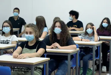  ??  ?? Sui banchi
Una classe delle superiori in aula, tutti con mascherina al banco così come previsto dai protocolli