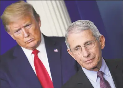  ?? Mandel Ngan / AFP via Getty Images ?? Director of the National Institute of Allergy and Infectious Diseases Anthony Fauci, flanked by President Donald Trump, speaks during the daily COVID-19 briefing at the White House in Washington on April 22.