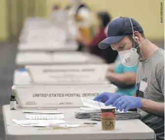  ??  ?? Workers prepare mail- in ballots for counting Wednesday at the convention center in Lancaster, Pennsylvan­ia.