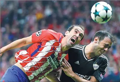  ?? PAUL WHITE / AP ?? Atletico Madrid’s Diego Godin (left) and Qarabag's Elvin Ismayilov vie for a header during Tuesday’s Champions League Group C match at Wanda Metropolit­ano in Madrid on Tuesday. The match ended 1-1.